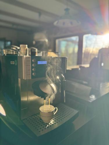 a coffee maker is making a cup of coffee at AMAYA SUITES nahe Heide Park, Serengeti Park & A7 in Soltau