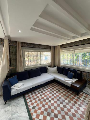 a living room with a couch and two windows at Villa prestige avec piscine in La Marsa