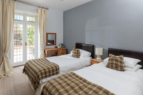 a bedroom with two beds and a window at The Hunters Inn in Martinhoe