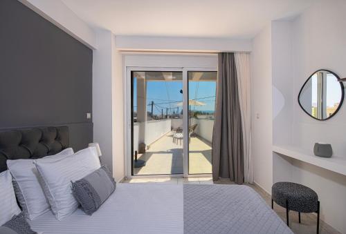 a bedroom with a bed and a view of a balcony at United Cretan Villas in Agia Marina Nea Kydonias
