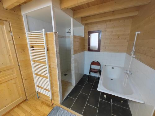 a bathroom with a tub and a chair in it at Appartement 75m2 - Centre-ville in Parthenay