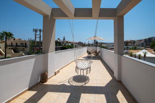 a balcony with a table and chairs and an umbrella at United Cretan Villas in Agia Marina Nea Kydonias