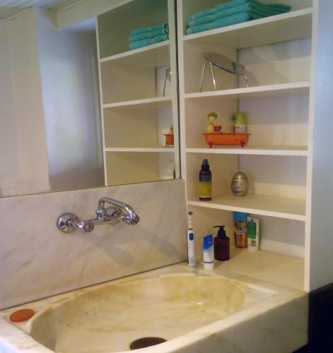 a bathroom with a sink and a shelf at Traditional Stonehouse in Potistika