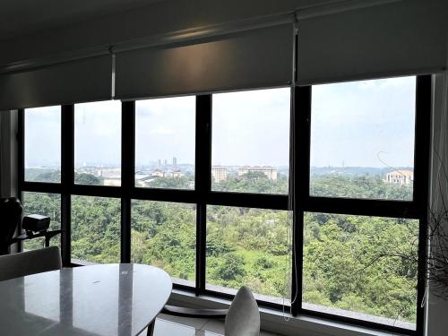 a room with a table and a large window at NEW Designer Condo - Panoramic Forest View - Steps To IOI City Mall - Your Best Urban Retreat in Putrajaya