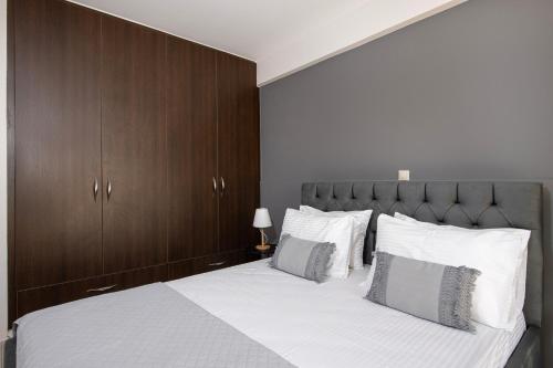 a bedroom with a large white bed with wooden cabinets at United Cretan Villas in Agia Marina Nea Kydonias