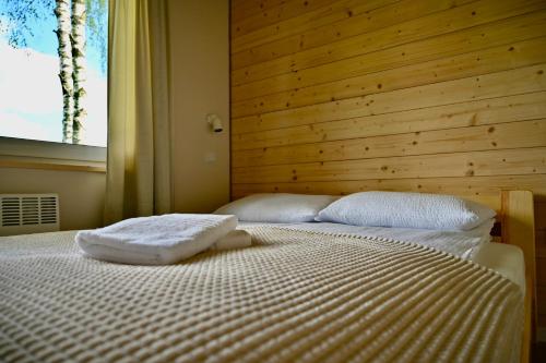 a bedroom with a bed with a wooden wall at Żubrowe Sioło - dom w naturze - najładniejsze widoki - nowość in Białowieża
