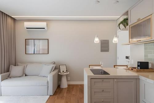 a living room with a couch and a kitchen at Aconchegante Studio no Cambuí in Campinas