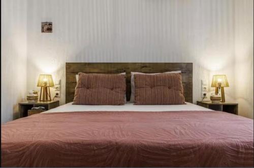 a bedroom with a large bed with two lamps at Wood in White in Panormos Skopelos