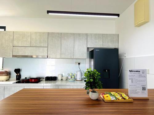 a kitchen with a wooden table and a black refrigerator at NEW Designer Condo - Panoramic Forest View - Steps To IOI City Mall - Your Best Urban Retreat in Putrajaya