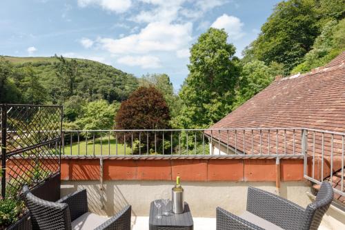 a balcony with chairs and a table with a bottle of wine at The Hunters Inn in Martinhoe