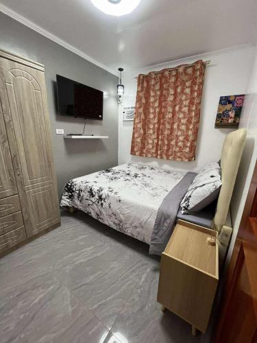 a bedroom with a bed and a flat screen tv at Compostela Guest Room #3 Terrace, Rooftop, WiFi, Netflix in Compostela