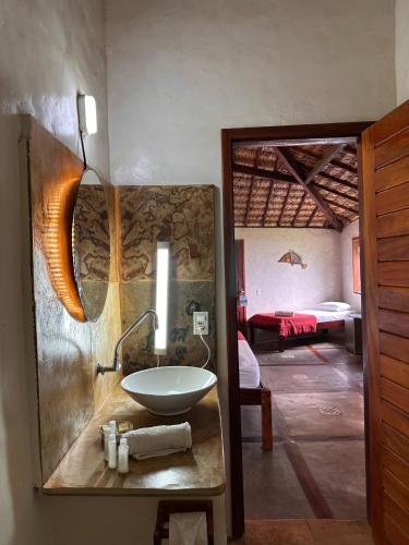 a bathroom with a sink and a room with a bedroom at Pousada Bate Vento in Itarema