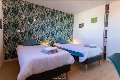 - 2 lits dans une chambre avec papier peint floral dans l'établissement Villa 4 personnes - 5 minutes mer - plein sud à trevou-treguignec pres de perro, à Trévou-Tréguignec