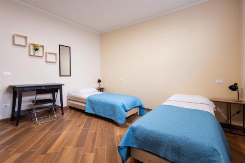 a room with two beds and a desk in it at IseoLakeRental - Fuori Porta in Tavernola Bergamasca