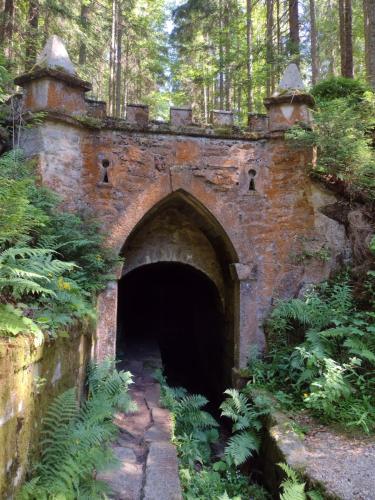 an old brick tunnel in the middle of a forest at Apartmány Na Vyhlídce - Wellness in Horní Planá