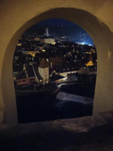 a view of a city through an arch in a bridge at Apartmány Na Vyhlídce - Wellness in Horní Planá
