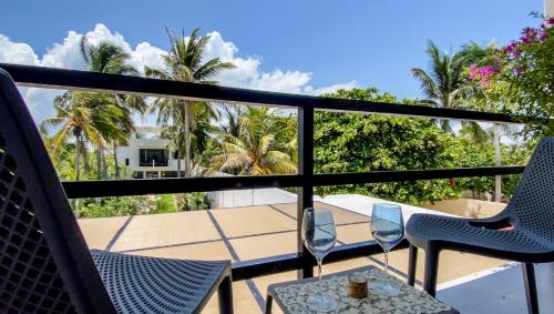 a balcony with chairs and a table and palm trees at Playanet in Chelem