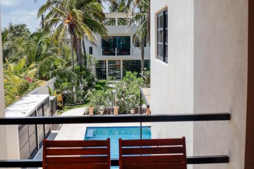 an apartment balcony with two chairs and a swimming pool at Playanet in Chelem