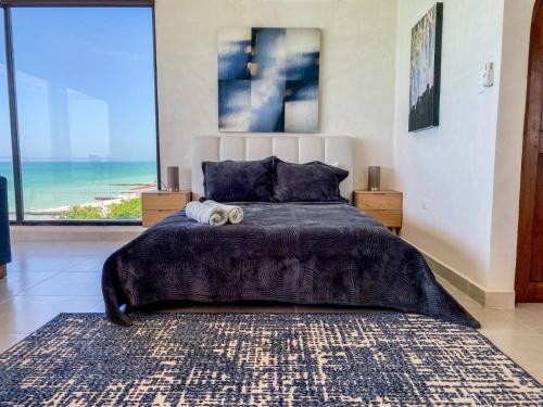 a bedroom with a large bed with a view of the ocean at Playanet in Chelem