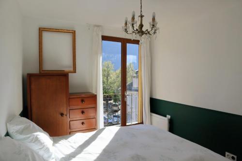 a bedroom with a bed and a mirror and a window at La myrtillette in Luchon