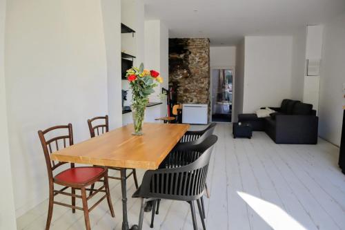 a vase of flowers on a wooden table in a living room at La myrtillette in Luchon