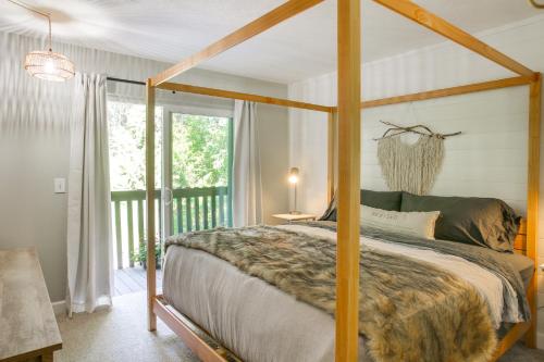 RathdrumにあるTwin Lakes Retreat Lake and Golf Access!の天蓋付きベッドとバルコニー付きのベッドルーム