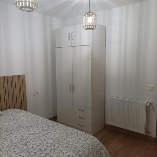 a bedroom with a white cabinet and two lights at Apartamento Rym in Siero