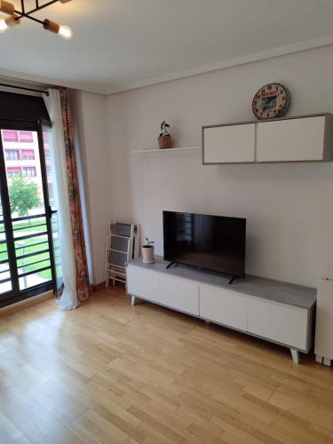 a living room with a flat screen tv on a white wall at Apartamento Rym in Siero