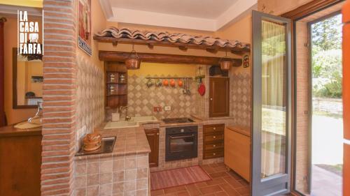 a kitchen with a sink and a stove at La Casa di Farfa - Lovely Home in Sabina in Bocchignano