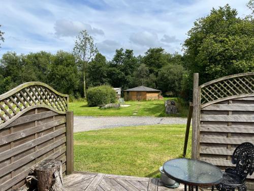 a pair of wooden gates with a table in a yard at Maes Y Grove Cottage in Carmarthen
