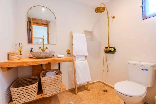 a bathroom with a toilet and a mirror at Villa Yakout in Ghazoua