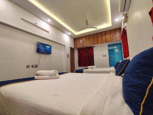 a bedroom with a large bed and a tv at THE VILLA Pondicherry in Puducherry