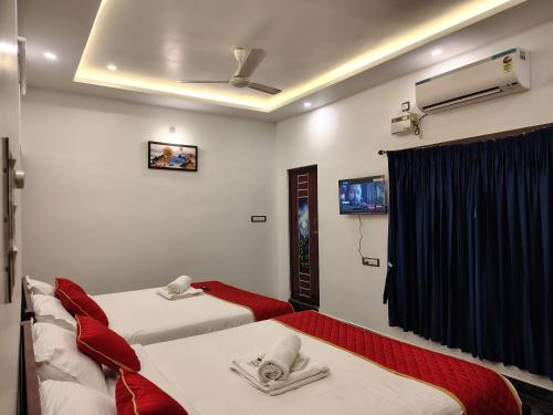 a hotel room with two beds and a tv at THE VILLA Pondicherry in Puducherry
