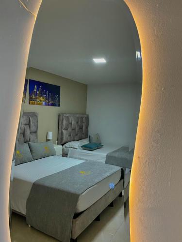 a hotel room with two beds and a couch at Hotel Santa Sofia in Bucaramanga