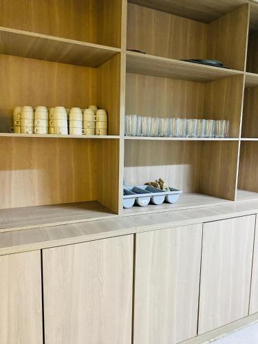 a kitchen with wooden cabinets with bowls and plates at Hotel Santa Sofia in Bucaramanga