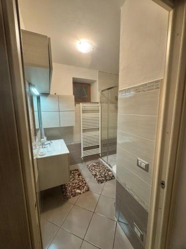 a bathroom with a shower and a sink and a mirror at Casa Nada in Neive