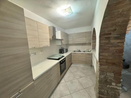 a kitchen with wooden cabinets and a stove top oven at Casa Nada in Neive