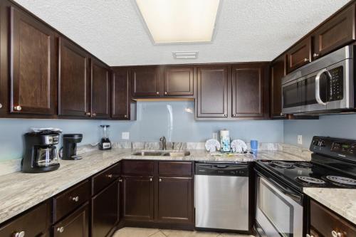 a kitchen with wooden cabinets and a stove top oven at Phoenix V 202 in Orange Beach