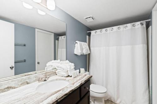 a bathroom with a sink and a toilet and a mirror at Phoenix V 202 in Orange Beach