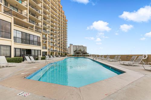 a swimming pool with lounge chairs and a building at Phoenix V 202 in Orange Beach