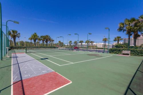 a tennis court with palm trees in the background at Phoenix V 202 in Orange Beach