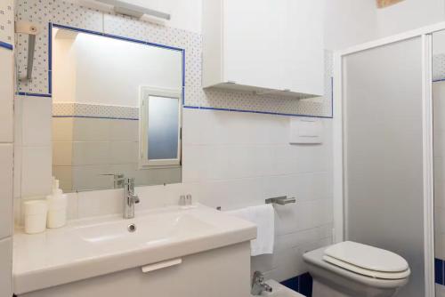 a bathroom with a sink and a toilet and a mirror at 2 apartments next to a market and Piazza Santa Croce - HomeUnity in Florence