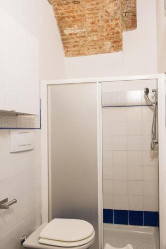 a white bathroom with a toilet and a shower at 2 apartments next to a market and Piazza Santa Croce - HomeUnity in Florence