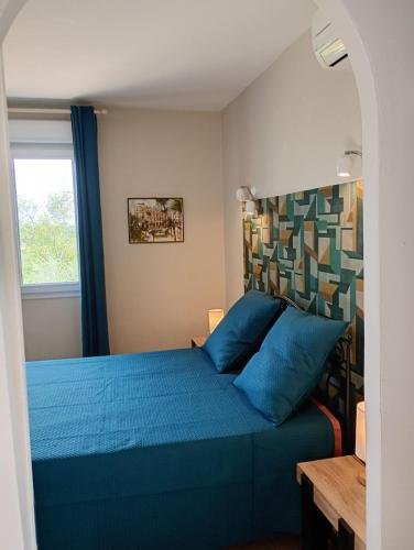une chambre avec un lit bleu et une fenêtre dans l'établissement chambre double pour adultes, à Combaillaux