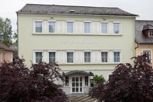 a white building with a sign on the front of it at Hametner mit Innviertlerhaus mit Thermenzugang in Bad Hall