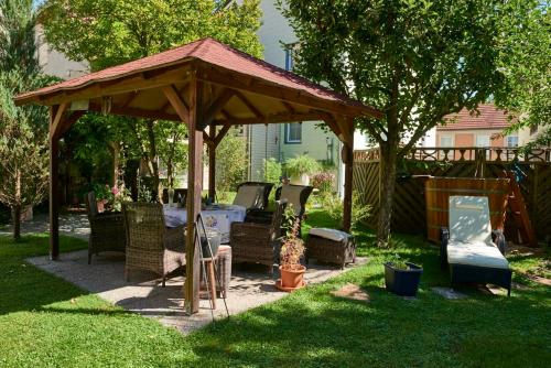 a wooden gazebo with chairs and a table in a yard at Hametner mit Innviertlerhaus mit Thermenzugang in Bad Hall