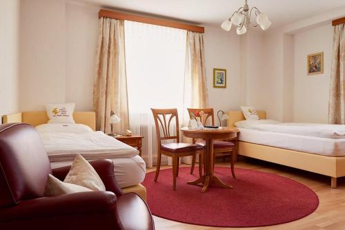 a bedroom with two beds and a table and a chair at Hametner mit Innviertlerhaus mit Thermenzugang in Bad Hall