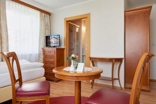 a hotel room with a table and a bedroom at Hametner mit Innviertlerhaus mit Thermenzugang in Bad Hall