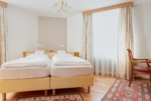 two twin beds in a bedroom with a chandelier at Hametner mit Innviertlerhaus mit Thermenzugang in Bad Hall