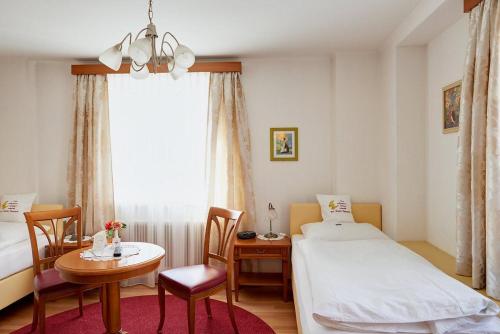 a hotel room with a bed and a table and a desk at Hametner mit Innviertlerhaus mit Thermenzugang in Bad Hall